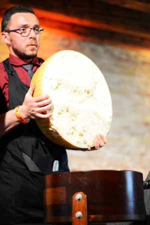 <b>L'arte del taglio di una forma di Parmigiano Reggiano   © Alice Ostan</b> - Igino Morini del Consorzio del Parmigiano Reggiano illustra le caratteristiche della forma appena aperta sul palco del congresso di alta cucina di Gusto in Scena.